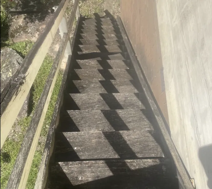 Timber staircase before cleaning — treads blackened with years of grime